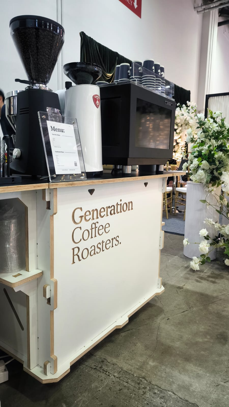 Generation Coffee Roasters coffee cart beside a floral wedding display