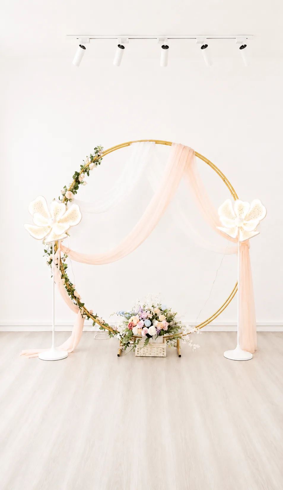 Gold round arch with pastel draping, organza flower lights and floral hedge