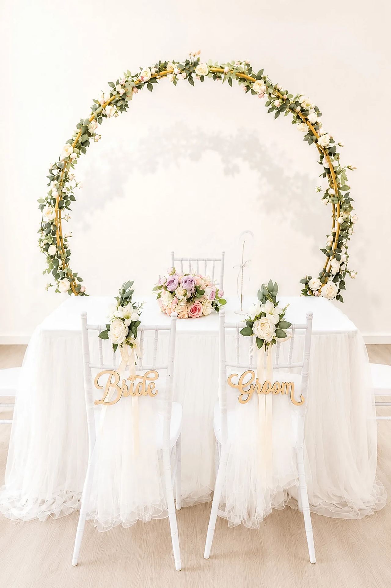 Solemnisation table and chairs beneath a full floral round arch