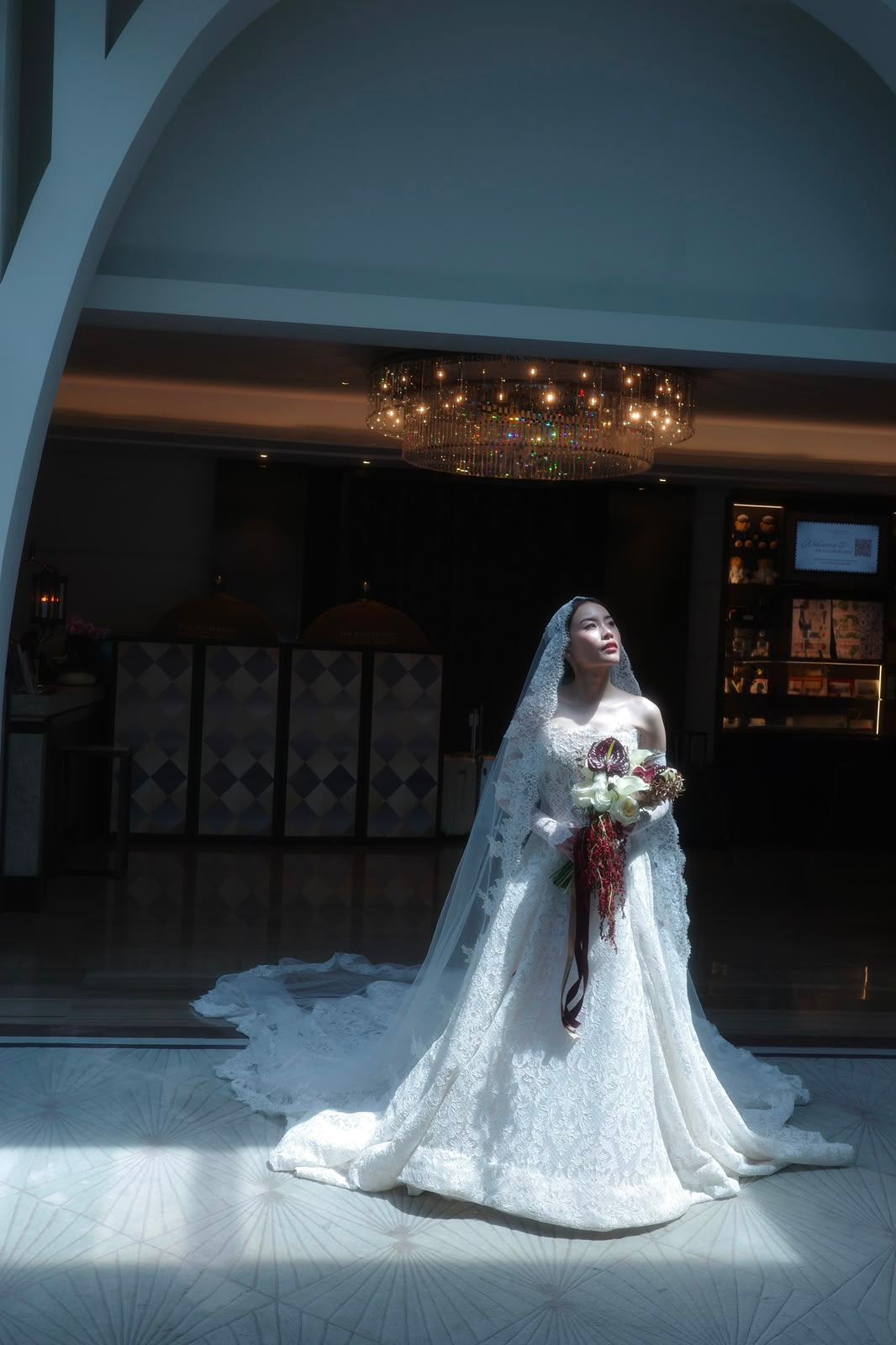 Bride in her wedding gown standing in a beam of light