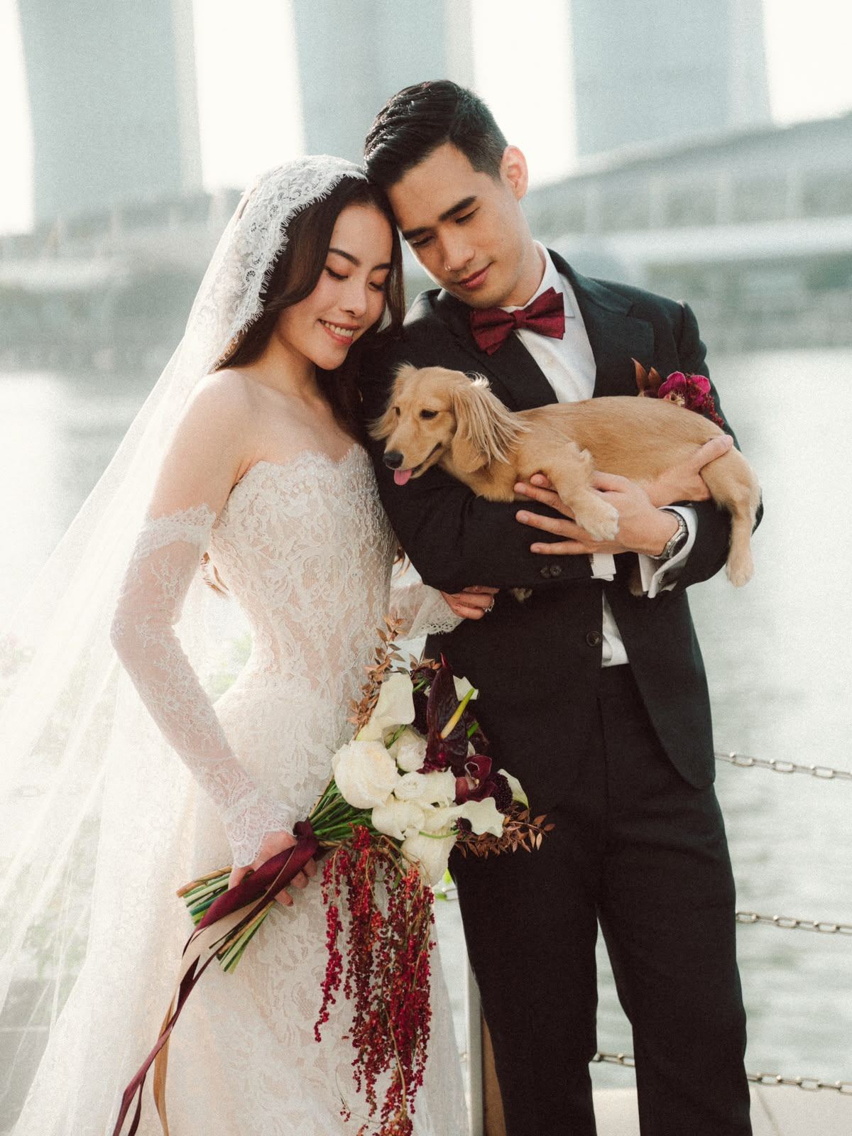 Bride and groom posing with their dog on their wedding day