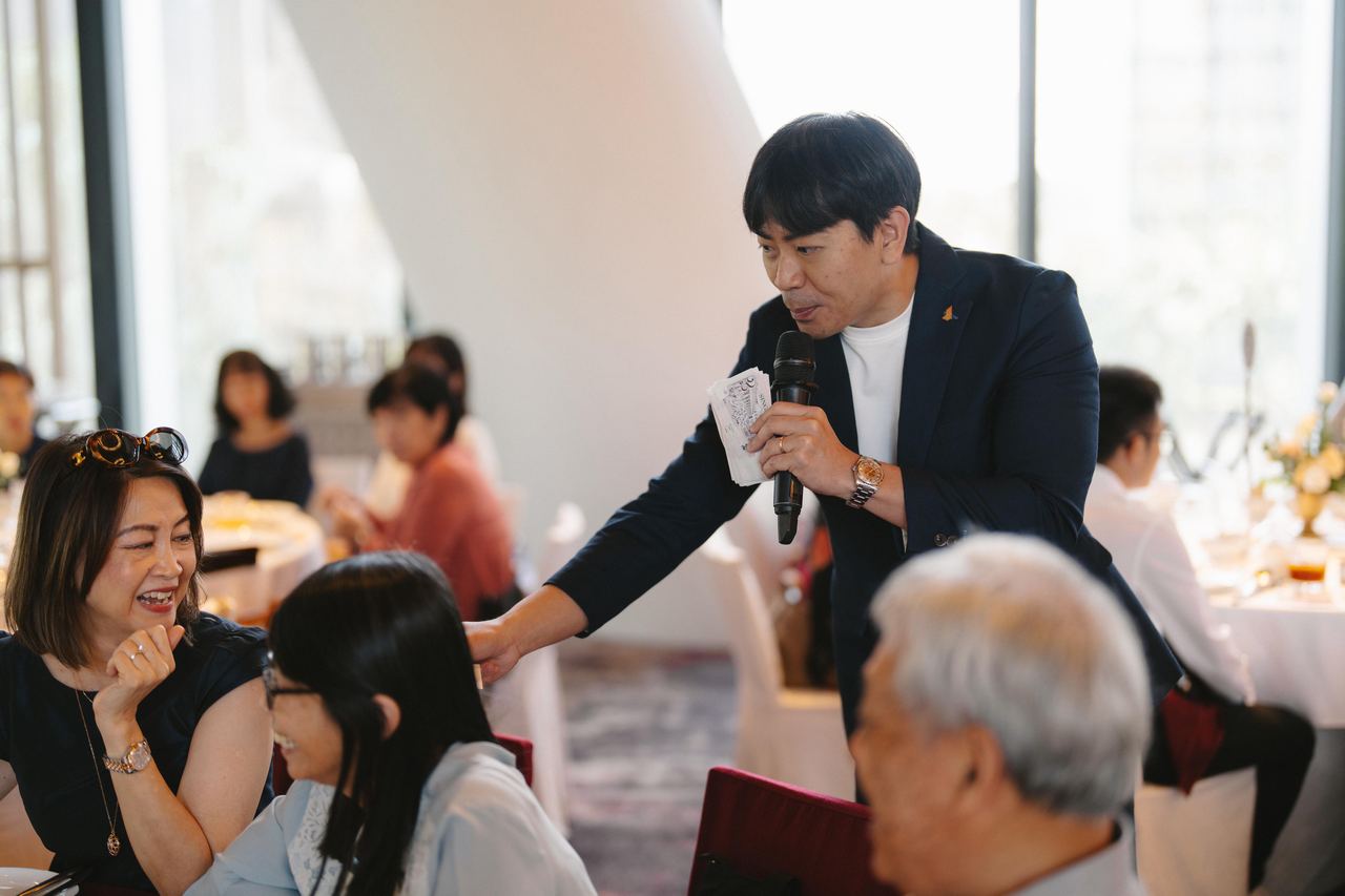 Emcee Rayson interacting with wedding guests at their table