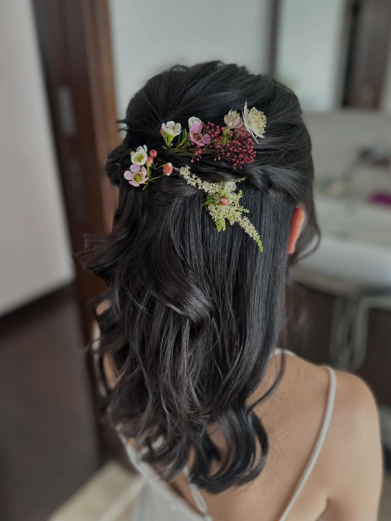 Bridal half-up hairstyle with fresh flowers by Clara Song Bridal