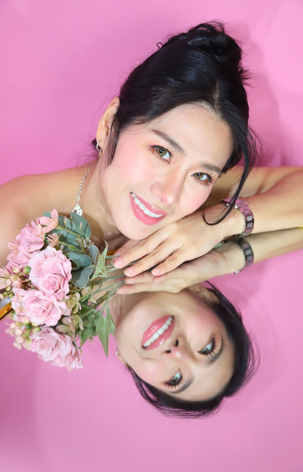 Close-up bridal portrait with pink flowers and a mirror reflection