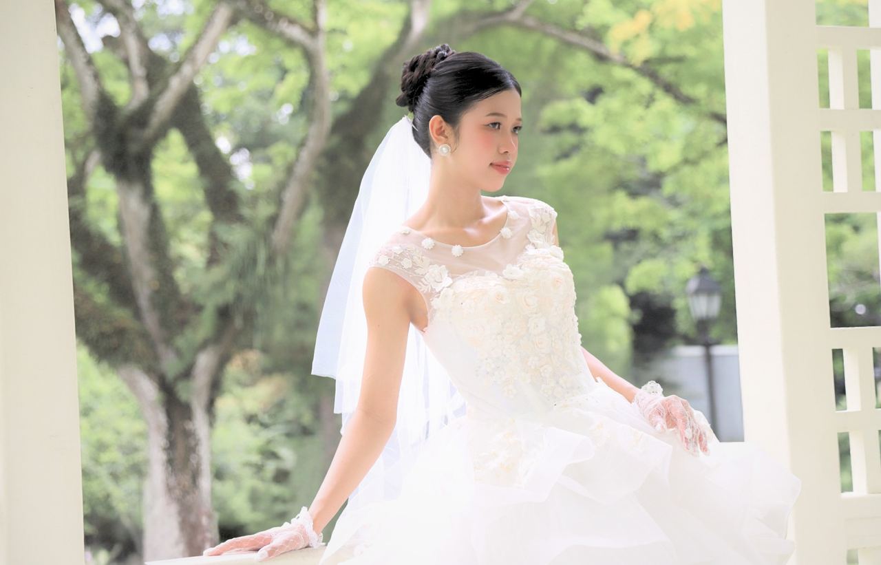 Bride in a white gown seated in an outdoor pavilion