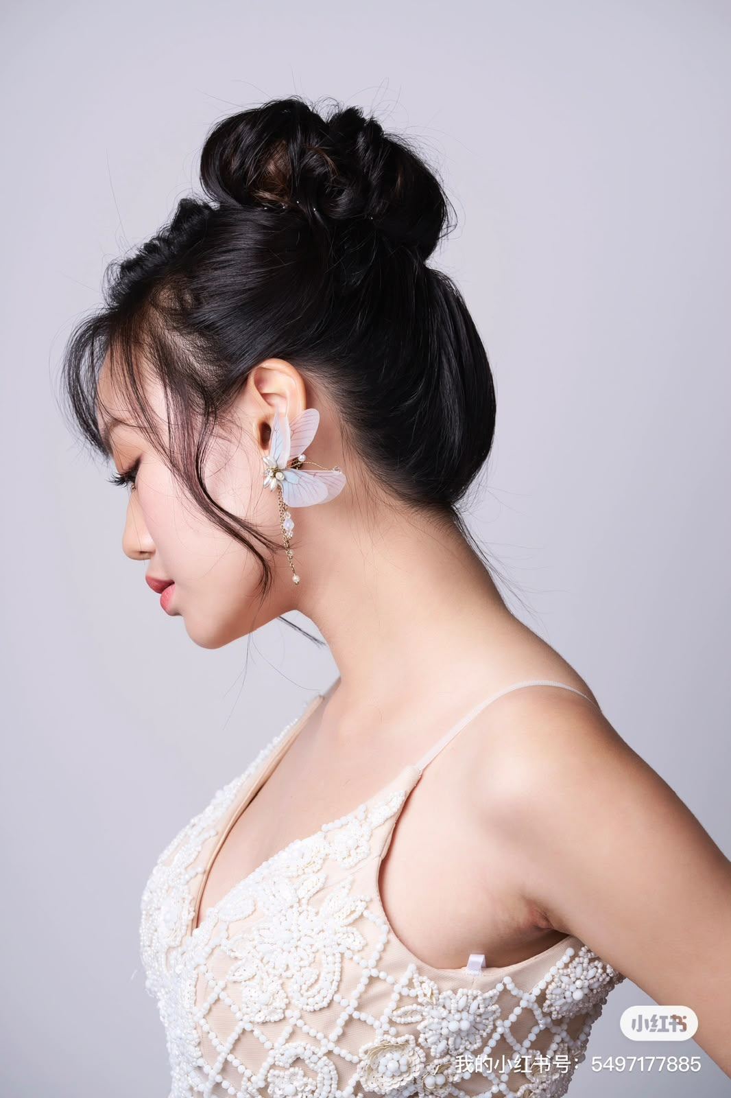 Bride in profile wearing a sculpted high bun and soft natural makeup by Elaine Beauty Studio