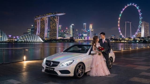 Couple beside an Eva Car Rental Mercedes cabriolet on the Marina Bay waterfront