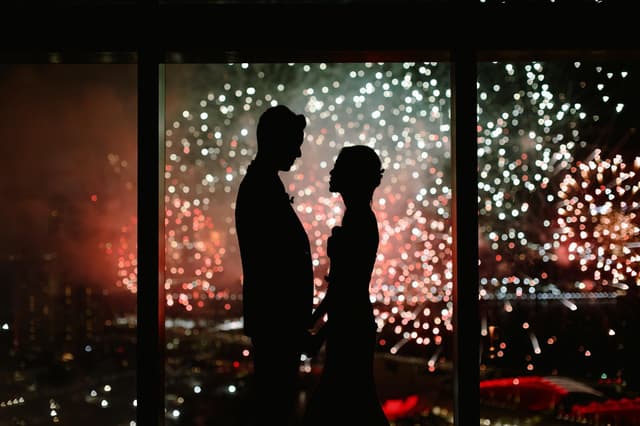 Wedding couple silhouetted against Marina Bay fireworks at Altro Zafferano