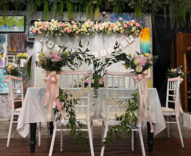 Bride and groom seating with floral wedding backdrop at Knots Cafe & Living
