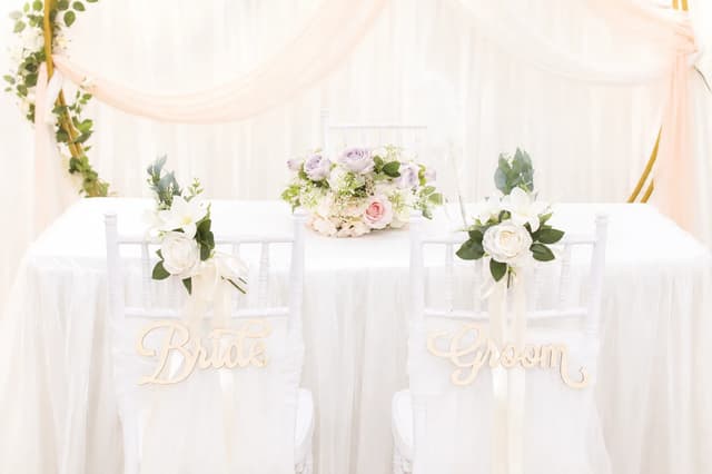 Bride and Groom chair signs with pastel floral table styling