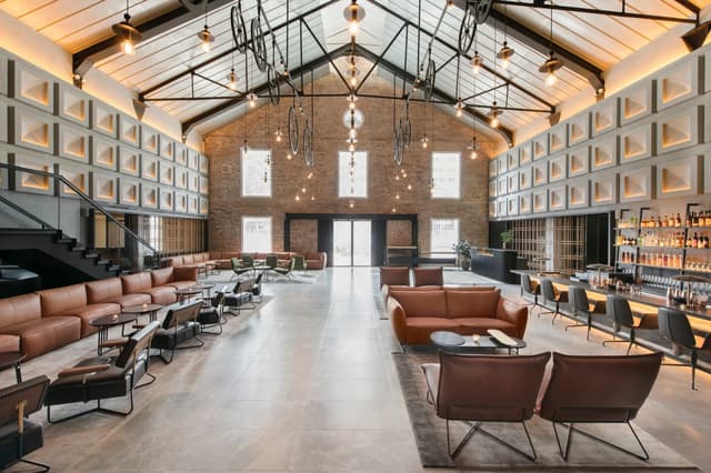 Wide view of The Warehouse Hotel lobby with high ceilings and hanging lights