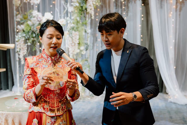 Emcee Rayson assisting a bride during a wedding speech