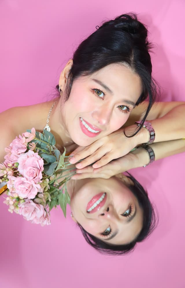 Close-up bridal portrait with pink flowers and a mirror reflection